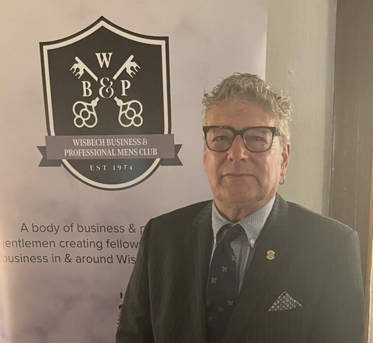 Man standing in front of business club banner.
