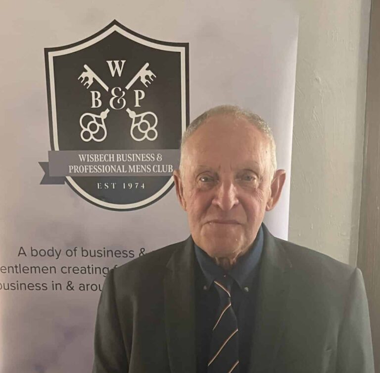 Man standing in front of club banner.