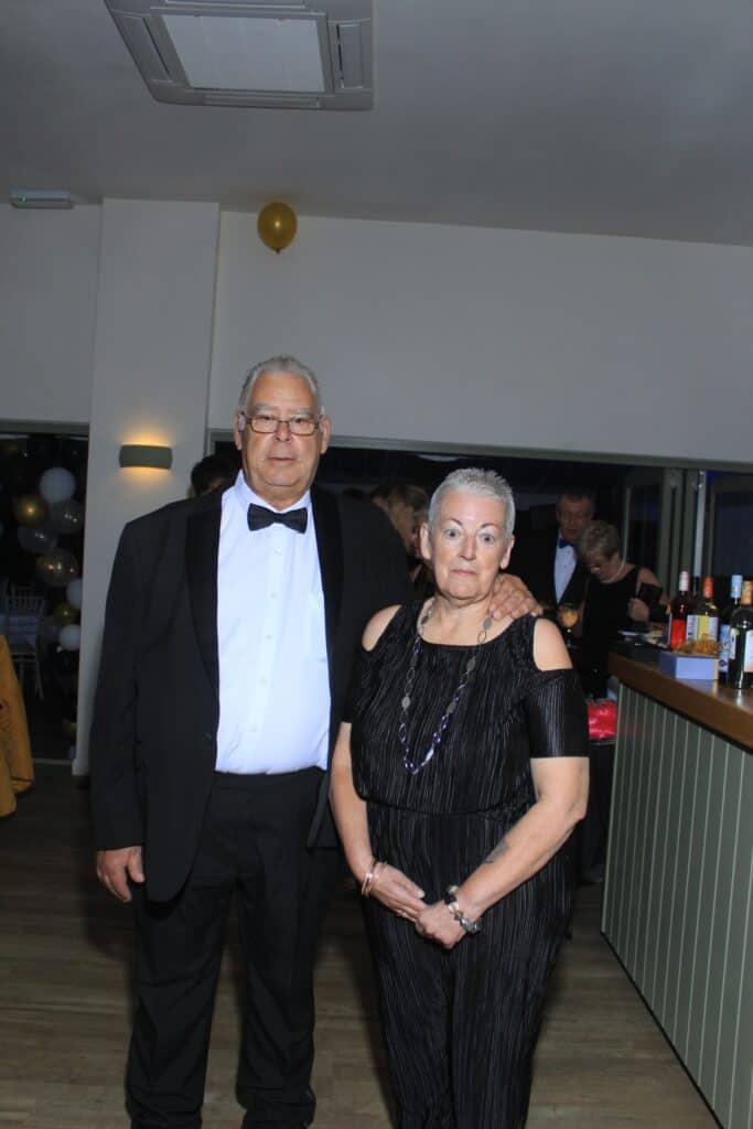 Elderly couple dressed formally at a party.
